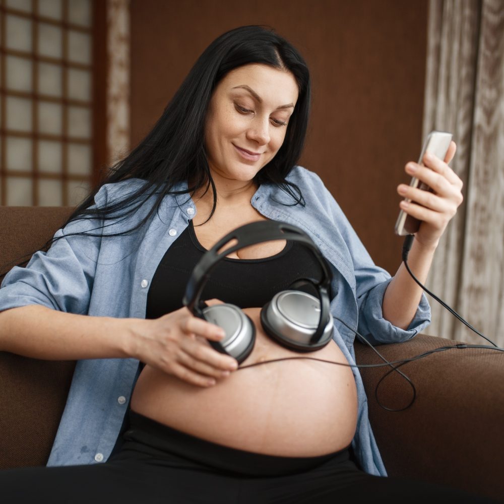 Pregnant woman listens to music with her baby