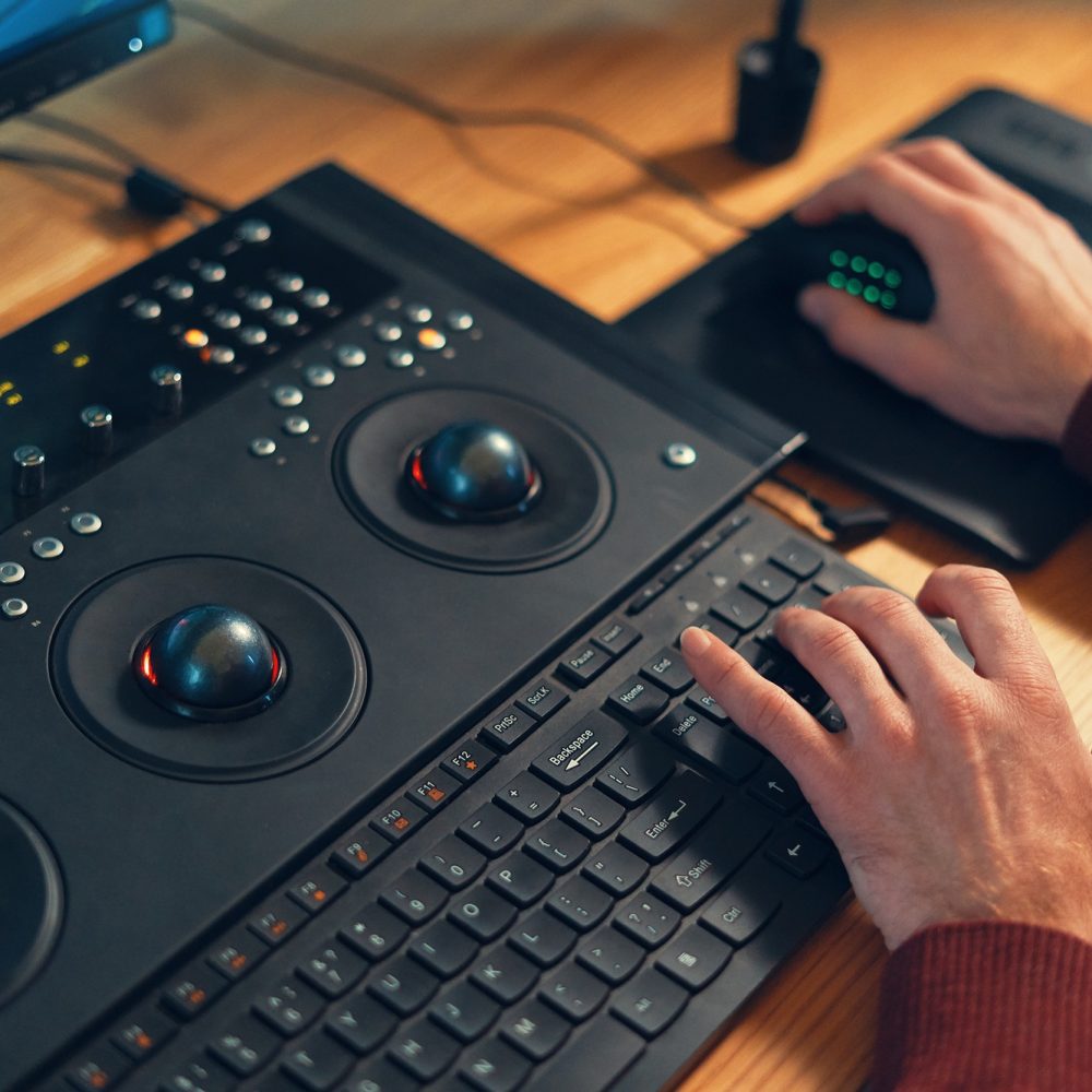 Video editor hands adjusting color or sound on working console machine